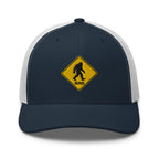 Bigfoot crossing sign embroidered navy trucker hat white mesh front view – funny hiking outdoor cap